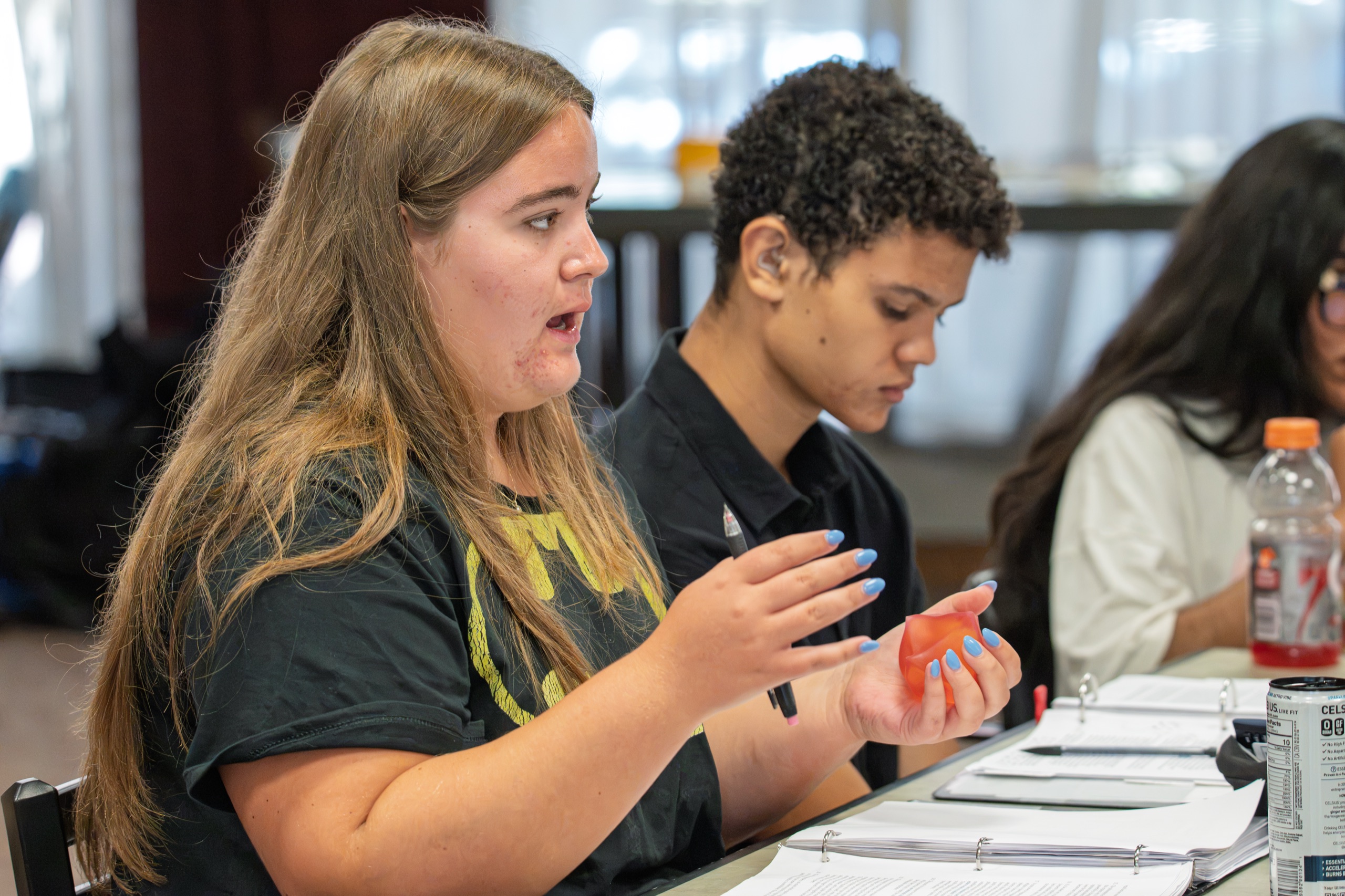 A Great Connections Seminar participant making a point mid-discussion, her binder of readings open beside her